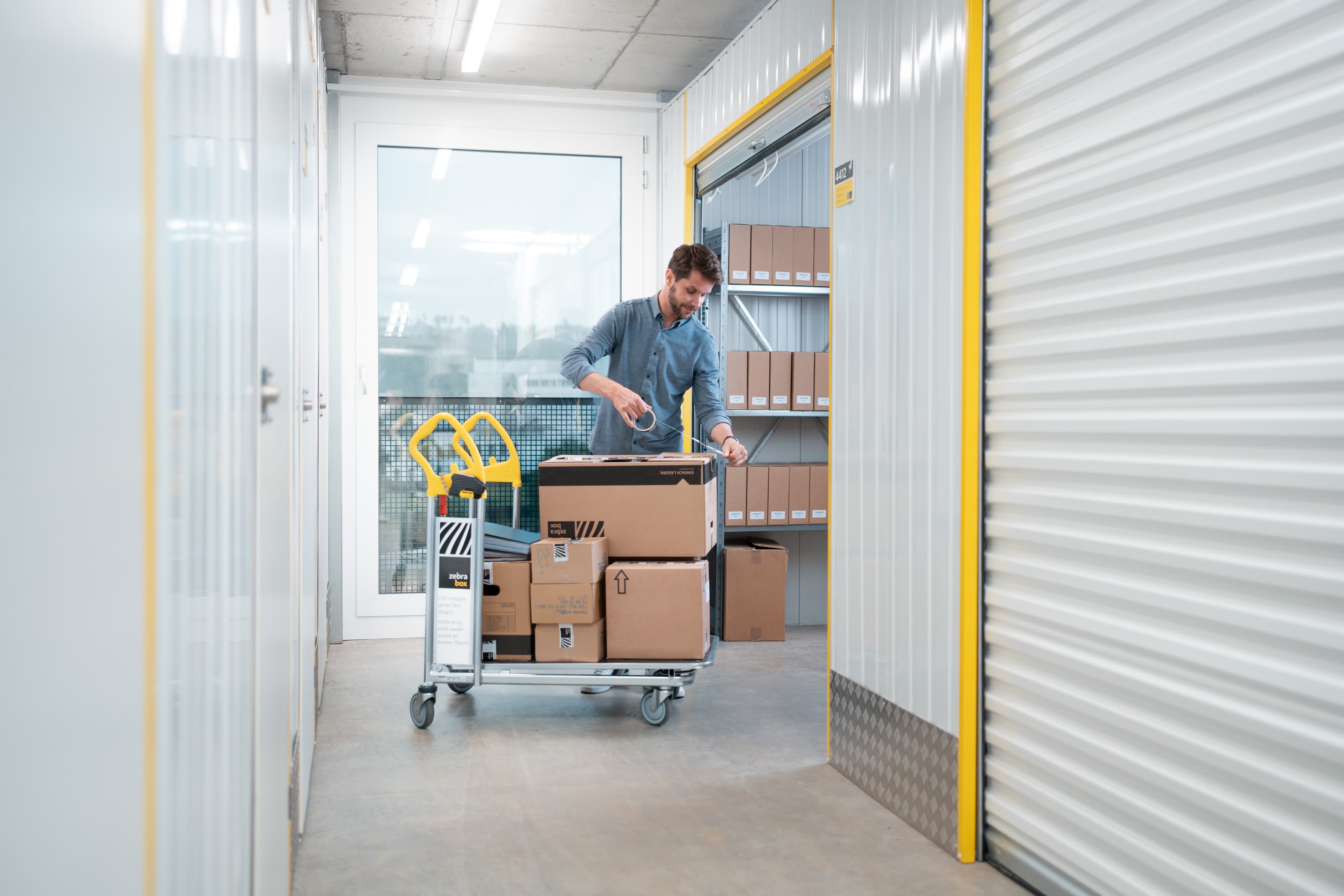 Un hombre almacena cajas de mudanza y cajas de archivo en el trastero de la empresa en Zebrabox.