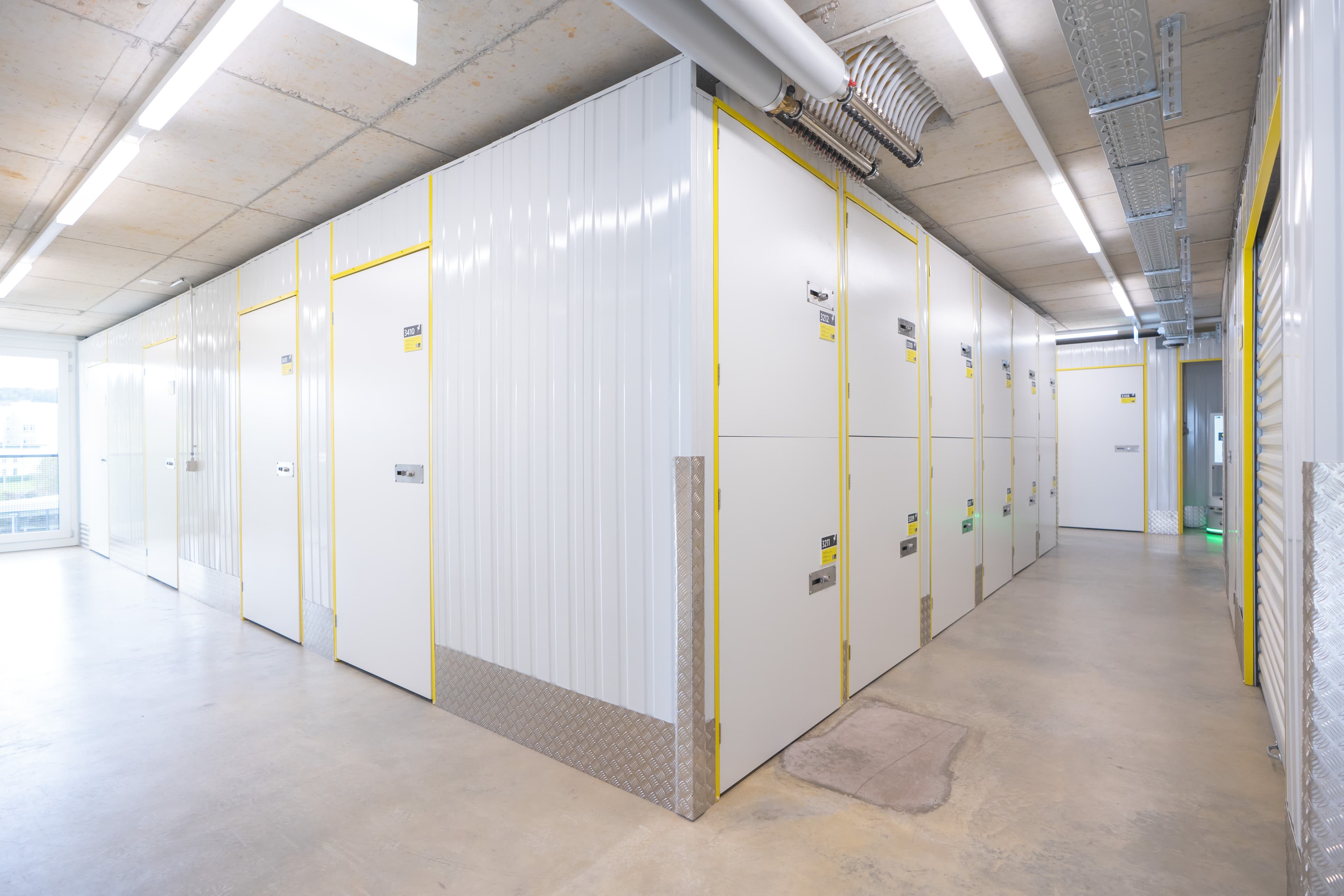 Interior view of the Zebrabox warehouse with individual storage units. The walls are made of sturdy white steel with yellow-edged doors.