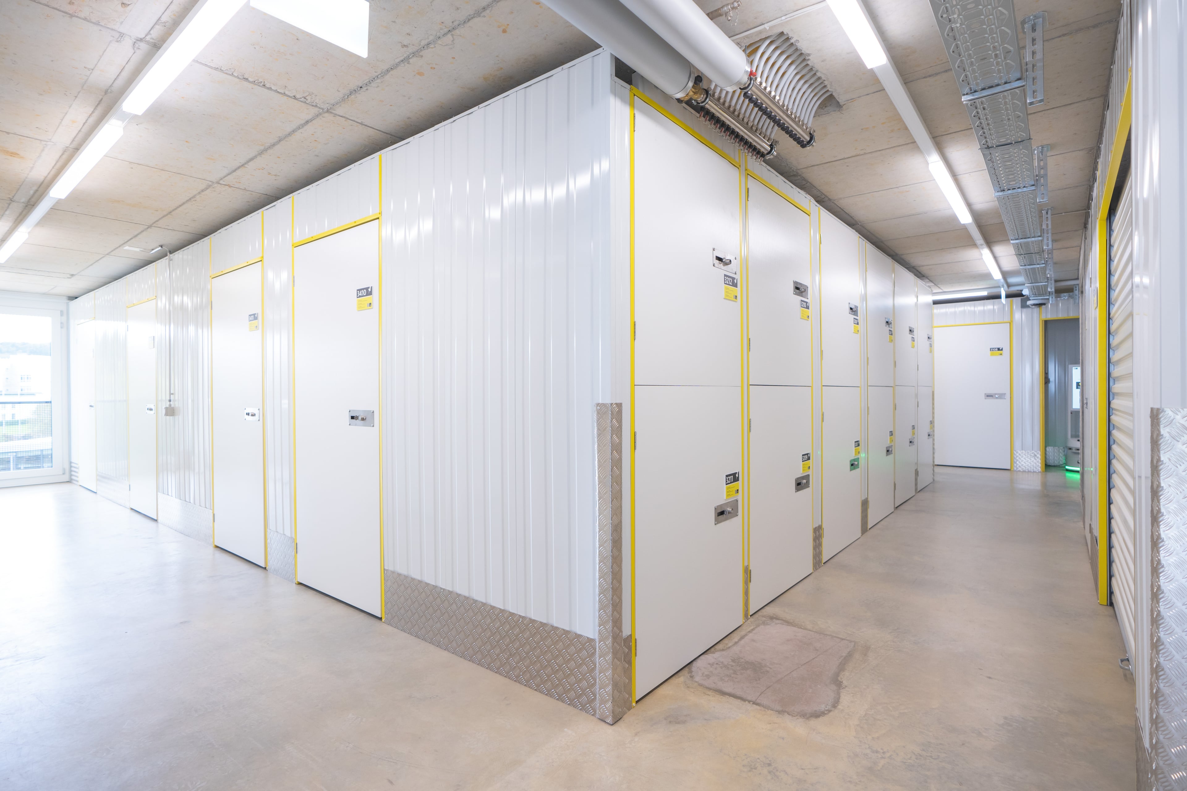 Interior view of the Zebrabox warehouse with individual storage units. The walls are made of sturdy white steel with yellow-edged doors.